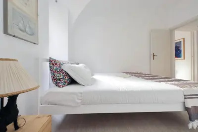 a white bedroom with a bed with pillows on it at Cimarra Apartment in Rome