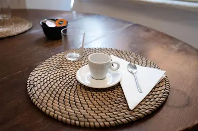 a plate with a cup and a napkin with a glass at Piazza Navona - Tiny House in Rome