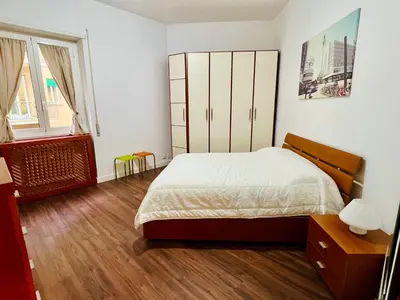 a bedroom with a bed and a dresser at Elegant Apartment Villa Bianca in Rome