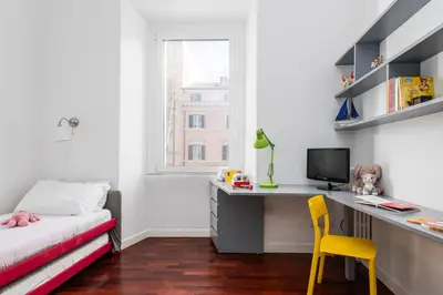 a bedroom with a desk and a bed with a yellow chair at Colosseum Home-ZENO 32 in Rome