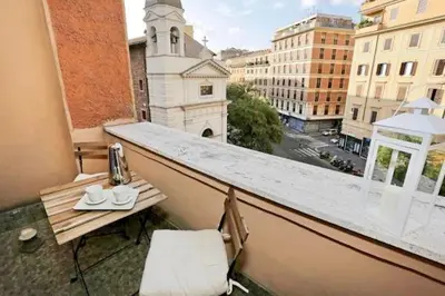 a balcony with a table and a view of a city at San Vito Suites in Rome