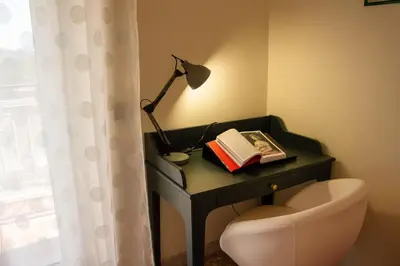 a desk with a lamp and a book and a chair at Luminoso non lontano dalla stazione TERMINI in Rome