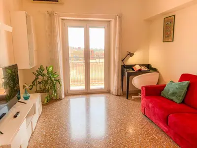 a living room with a red couch and a window at Luminoso non lontano dalla stazione TERMINI in Rome