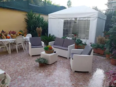 a patio with chairs and a table and a white tent at Il giardino di Marimar in Rome