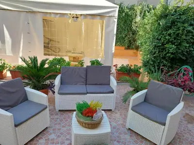 a patio with three chairs and a table with a bowl of fruit at Il giardino di Marimar in Rome