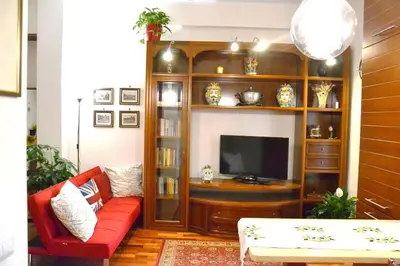 a living room with a red couch and a television at La Casudda di Ro' - metro A Battistini in Rome