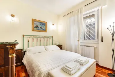 a bedroom with a bed with white sheets and a window at La Casudda di Ro' - metro A Battistini in Rome