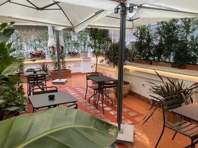 a patio with tables and chairs under an umbrella at Affreschi al Pantheon in Rome