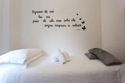 a bedroom with a bed with words on the wall at Podesti House - Flaminio Stadio Olimpico in Rome