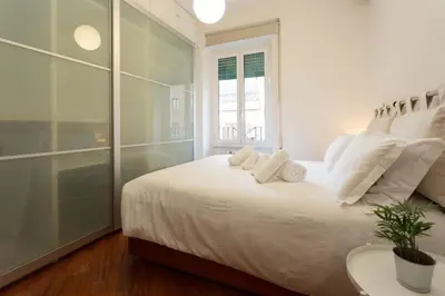 a white bedroom with a large bed with white pillows at Podesti House - Flaminio Stadio Olimpico in Rome