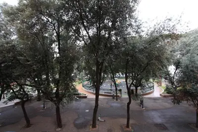 a group of trees in a park with a fountain at Testaccio Holiday House in Rome