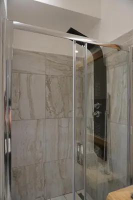 a shower with a glass door in a bathroom at Penna Relais al Corso in Rome