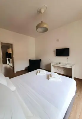 a large white bed in a room with a tv at Cave Apartment in Rome