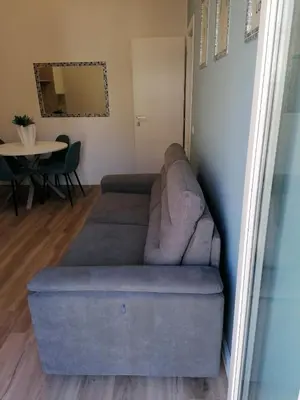 a couch in a living room with a table at Capitale Bullicante in Rome