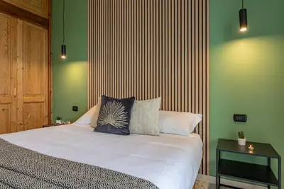 a bedroom with a bed with a striped wall at Viola Penthouse with Rome Panoramic View in Rome