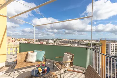 a balcony with two chairs and a table on a building at Viola Penthouse with Rome Panoramic View in Rome