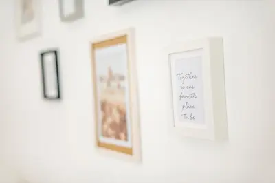 a white wall with framed pictures on it at The vatican garden in Rome
