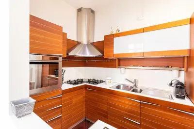 a kitchen with wooden cabinets and a sink at La corte di Merlino - Apt centrale di pregio in Rome