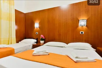 two beds in a room with wooden walls at TERMINI STAR in Rome