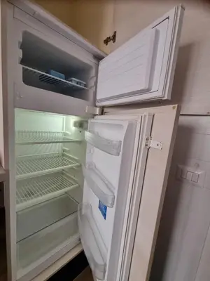 an empty refrigerator with its door open in a kitchen at San Paolo Casa Bella in Rome