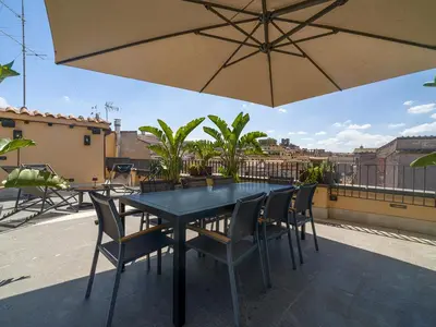 a table and chairs under an umbrella on a patio at LUXURY Terrazza Privata su Fontana di Trevi in Rome