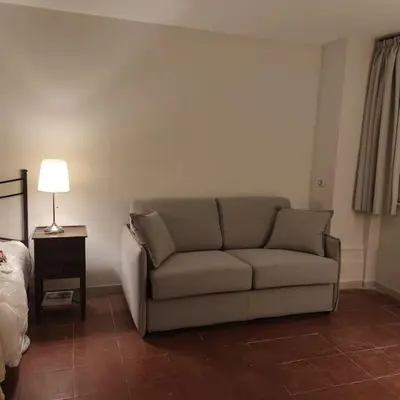 a living room with a couch next to a bed at Discover the Pantheon from The Berardi Studio Flat in Rome
