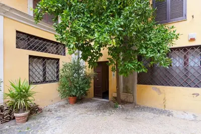 a yellow building with a door and some plants at Discover the Pantheon from The Berardi Studio Flat in Rome