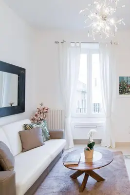 a living room with a white couch and a table at Brightful Boutique Apartment in the Heart of Trastevere in Rome