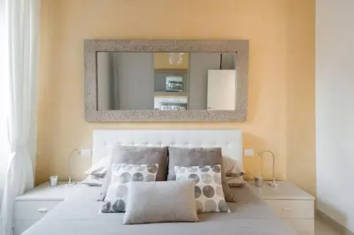 a bedroom with a large mirror above a bed at Brightful Boutique Apartment in the Heart of Trastevere in Rome