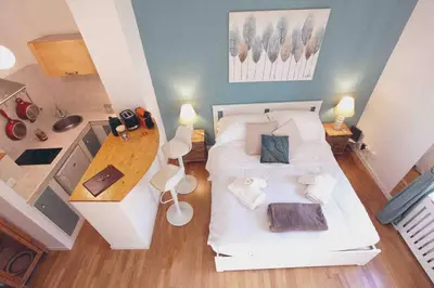 a bedroom with a white bed and a wooden table at Urbana Suite in Rome