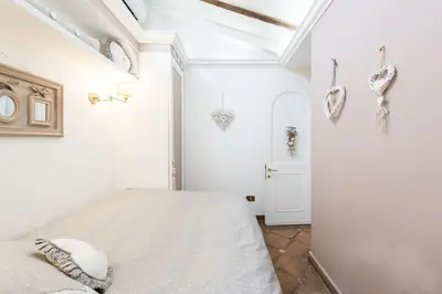 a white bedroom with a bed in a room at Piazza Navona - Penthouse in the heart of Rome in Rome
