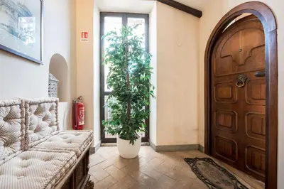 a living room with a door and two plants at Piazza Navona - Penthouse in the heart of Rome in Rome