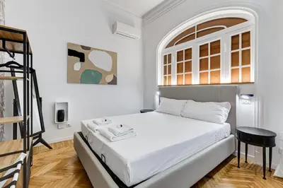 a white bedroom with a bed and a ladder at BMGA l Gracchi Lux Lovely 3Bdr Apartment in Rome