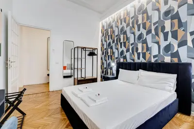 a bedroom with a bed with a blue and white wall at BMGA l Gracchi Lux Lovely 3Bdr Apartment in Rome
