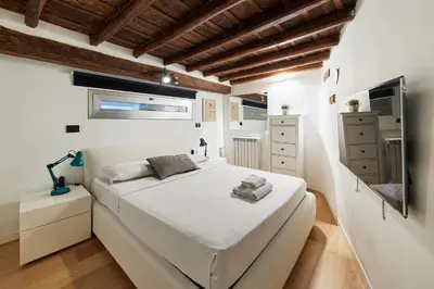 a white bedroom with a bed and a window at iFlat Marvellous home near Via del Corso in Rome