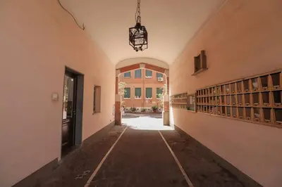 an empty hallway of a building with a chandelier at San Pietro - moderno appartamento in Rome