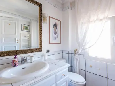 a bathroom with a sink and a toilet and a mirror at Apartment Santa Cecilia View by Interhome in Rome