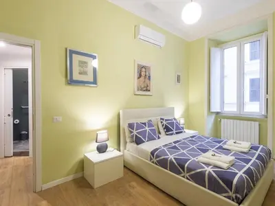 a bedroom with a bed with a blue comforter and a window at Apartment Porta Magica by Interhome in Rome
