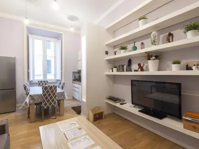 a living room with a flat screen tv and shelves at Apartment Porta Magica by Interhome in Rome