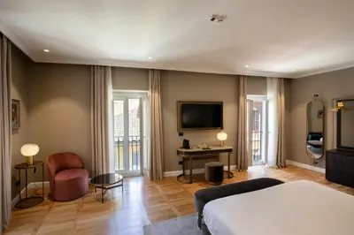 a bedroom with a bed and a desk and a tv at Condotti Belvedere in Rome