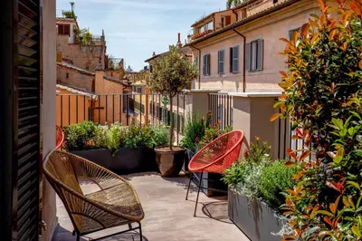 a patio with chairs and plants on a balcony at Condotti Belvedere in Rome