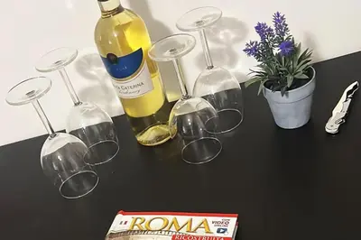 a table with glasses and a bottle of wine at 150 meters from the Colosseum - Appartmento Gladiatore in Rome