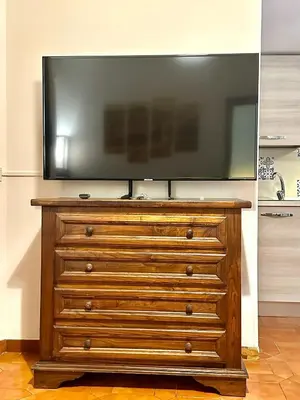 a television on top of a wooden dresser at 150 meters from the Colosseum - Appartmento Gladiatore in Rome