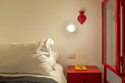 a bedroom with a bed and a red table with a book at Farina 36 in Rome