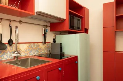 a kitchen with red cabinets and a white refrigerator at Farina 36 in Rome