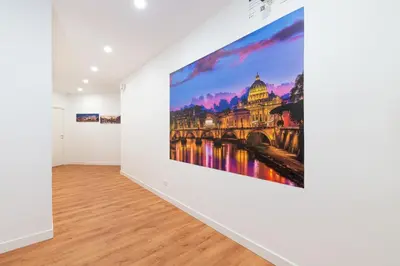a large painting hangs on a wall in a white room at Roma Mia in Trastevere in Rome