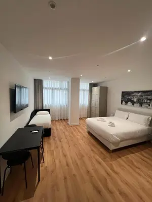 a hotel room with two beds and a desk at Roma Mia in Trastevere in Rome