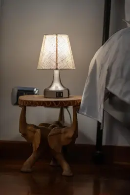a table with a lamp on it next to a bed at PgrHome Boschetto in Rome