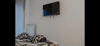 a bed with two pillows and a television on a wall at Monti Royal Apartment in Rome