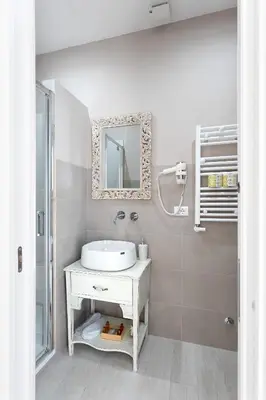 a white bathroom with a sink and a mirror at Colosseo House in Rome